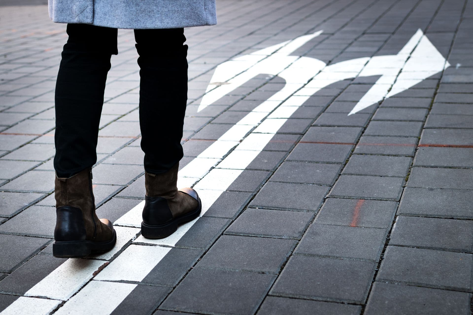 Photo of a person walking towards an arrow.